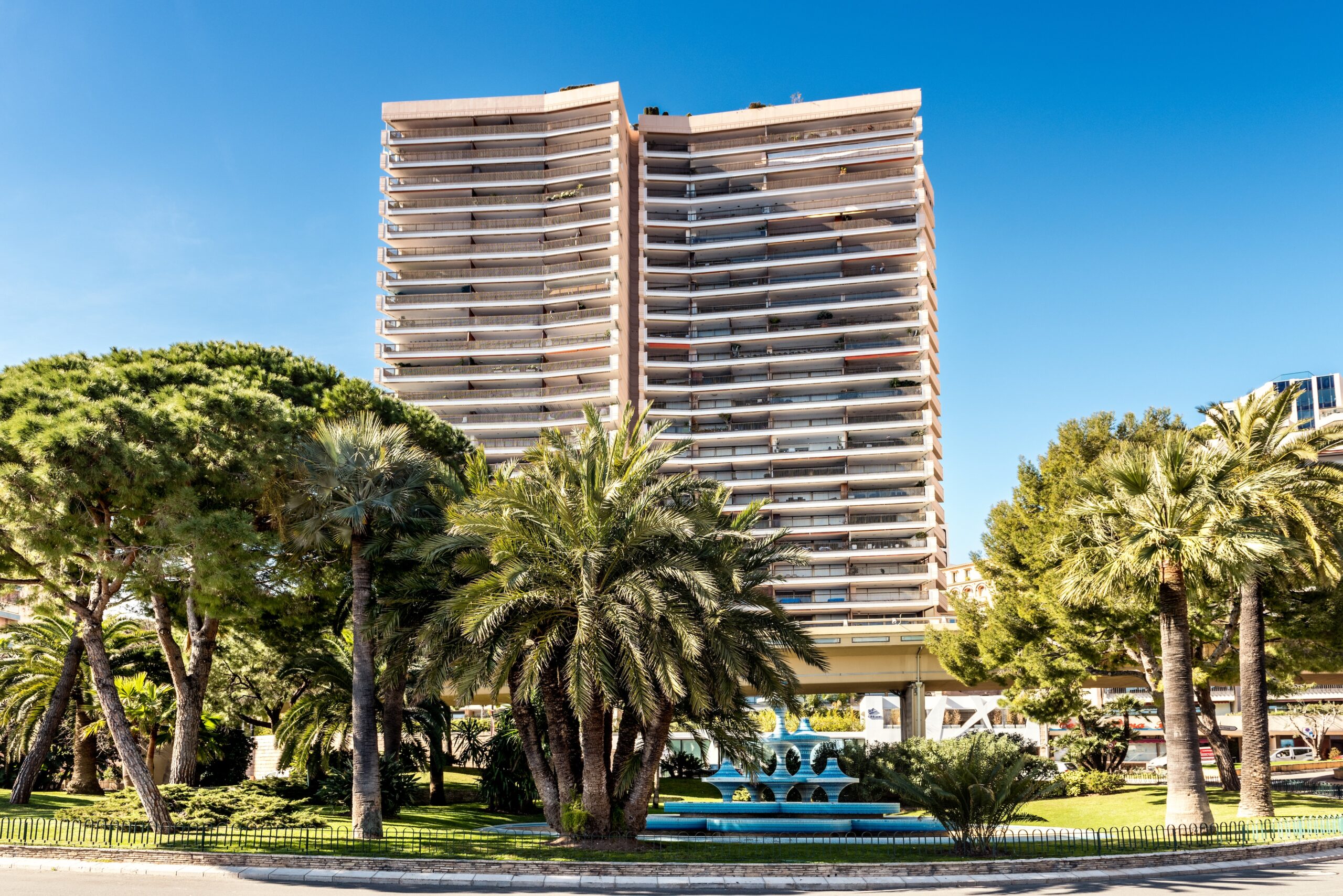 Mirabeau building surrounded by plam trees on a sunny day with clear sky